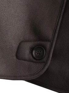 Détail macro de la texture du manteau marron avec bouton rond et couture précise