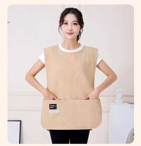 Close-up of beige apron vest with large pocket and barista labels on a neutral background