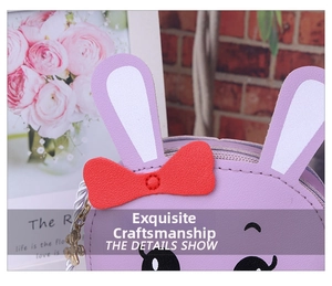 Detail of a purple bunny shoulder bag with red polka dot bow and metal zipper puller