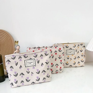 Three corduroy tulip makeup bags in purple, red, and yellow shown on a clean white surface