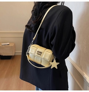 Détail du sac bandoulière jaune en PU tissé avec pendentif étoile et boucle métal