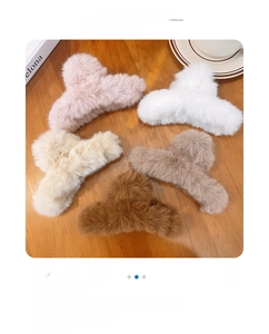Five plush faux fur claw clips in pastel tones displayed on a rustic wooden table