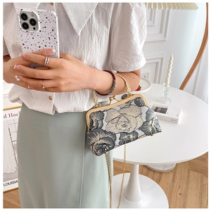Detailed view of floral embroidery on a vintage style cheongsam bag with metal handle