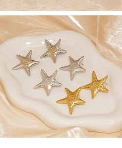 Detailed view of starfish stud earrings with hammered metal texture on a ceramic tray