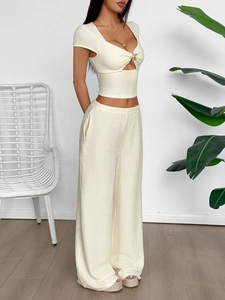 Elegant beige short sleeve knit set with heart neckline and gold buttons in a bright room