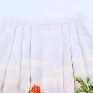 Détail de la jupe midi plissée à taille haute avec imprimé tropical de plage et palmiers