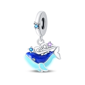 Détail macro d'une breloque baleine bleue avec vagues en argent et gemmes étincelantes