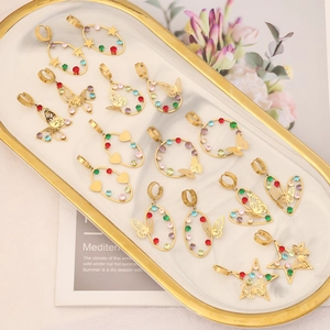 Close-up of golden butterfly and star earrings with colorful crystals on a tray