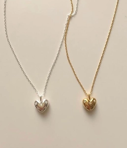 Detail of silver and gold heart pendants featuring shimmering pavé set rhinestones