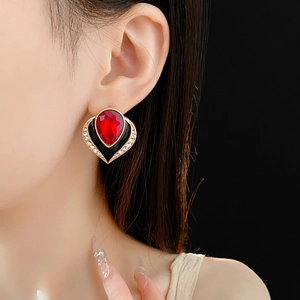 Close-up of vintage heart earring with red crystal and black enamel on model's ear