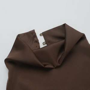 Close-up of high-neck satin dress with back button closure detail in dark brown