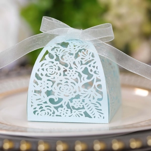 Detail of light blue laser-cut paper wedding favor box with delicate flower patterns