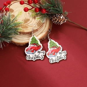 Festive Christmas acrylic earrings featuring red truck and tree design on wood background