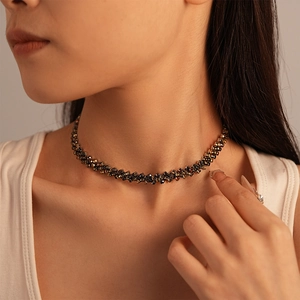Close-up of a vintage contrast choker necklace with dark crystals on a model's neck