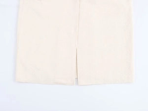 Close-up of off-white long wool coat showing split hem and heavy texture detail