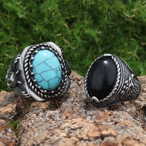 Detailed view of vintage turquoise and tiger eye rings placed on natural tree bark