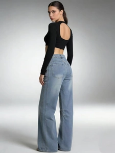 Women's light blue wide-leg jeans paired with a backless long-sleeve crop top