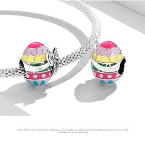 Gros plan d'un bracelet en argent S925 avec des breloques d'œufs de Pâques émaillés colorés