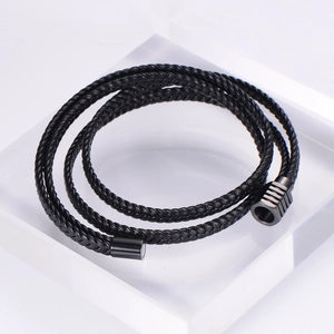 Detail of multi-layer black braided leather bracelet with black magnetic clasp closure