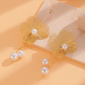 Detail view of gold hollow flower earrings with elegant long tassels and pearl pendants