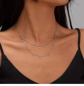 Detail of double-layer 925 silver necklace with sparkling zircon stones on model neck