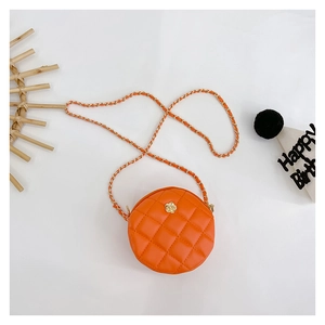 Detail of orange round quilted crossbody bag featuring a golden flower clasp and chain strap