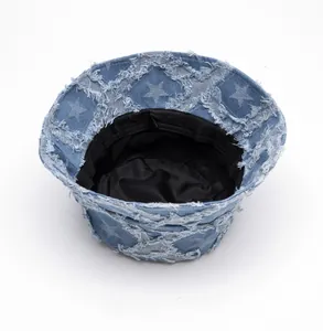 Detail view of denim bucket hat showing inner black lining and raw edge star pattern