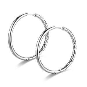 Close-up of silver titanium hoop earrings with unique hammered and smooth texture finish