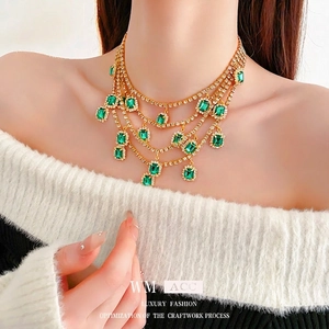 Luxurious tiered emerald fringe necklace with vintage gold finish and rectangular green stones