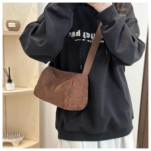 Detailed texture of dark brown corduroy tote bag with wide strap on shoulder