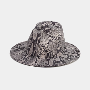 Detailed close-up of a stylish wide brim fedora hat featuring a trendy snakeskin pattern print