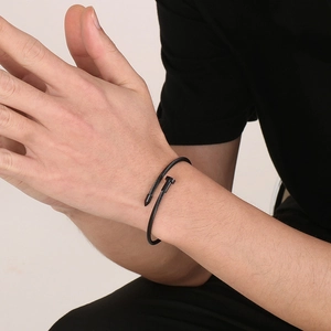 Men's black stainless steel nail bracelet with industrial cable texture on wrist