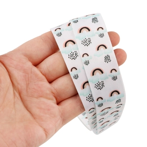 Detail of soft white rainbow printed lanyard ribbon texture and width held in hand