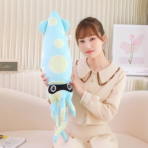 Detail view of a long blue plush squid toy with green dots held by a model in a cozy setting