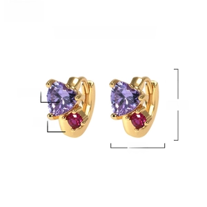 Detail view of gold brass heart earrings with purple zircon measuring 11mm by 8mm