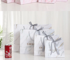Detail of marble pattern gift bags in four sizes with grey ribbon bows and Sweet Times print
