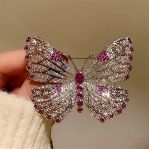 Detailed view of luxury butterfly brooch with sparkling crystals and pink corundum