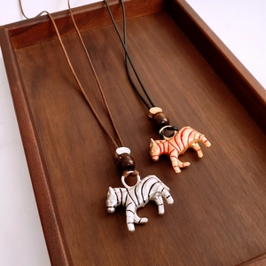 Detailed view of handmade zebra pendants with wood beads and adjustable leather cord necklace
