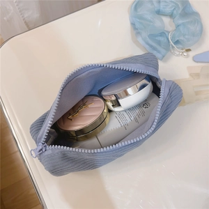 Close-up of blue corduroy cosmetic bag showing soft texture and spacious interior storage