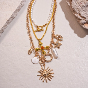 Multilayer gold necklace with freshwater pearls, starfish, shell and sun face charms