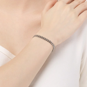 Detailed view of an elegant wheat-shaped stainless steel chain bracelet on a wrist