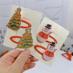 Detail of Christmas snowman and tree hair clips with glitter finish and fabric wrap