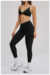 Dettaglio completo set yoga nero con leggings a vita alta incrociata e reggiseno