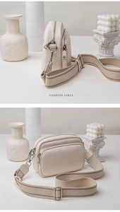 Close-up of beige crossbody bag with lychee texture and stylish wide fabric shoulder strap