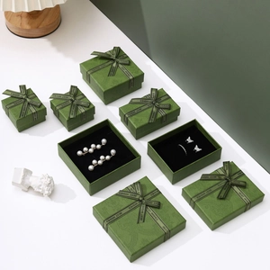 Elegant emerald green jewelry boxes with ribbon bows and textured finish for rings and necklaces
