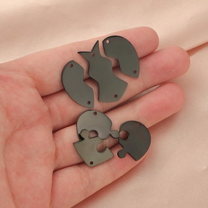 Pendentifs puzzle cœur et chien en acier inoxydable noir sur tissu de soie rose