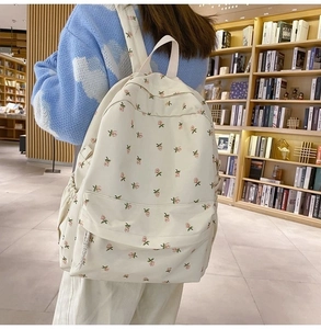 Detailed shot of floral canvas backpack on a model in a library setting with warm lighting