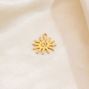 Detail of a gold sun pendant with spiral texture on a luxurious silk fabric background