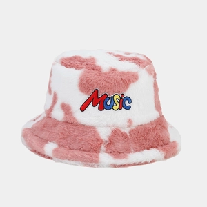 Close-up of pink cow print plush bucket hat featuring colorful Music letter embroidery