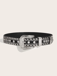 Dettaglio della fibbia d'argento decorata e degli strass scintillanti sulla cintura in pelle Y2K